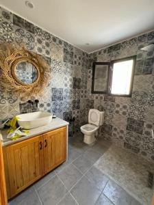 een badkamer met een wastafel, een toilet en een spiegel bij Dar FATMA in Houmt Souk +6 foto's