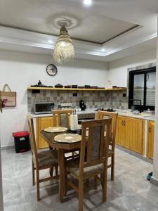 een keuken met een tafel en stoelen en een keuken met een fornuis bij Dar FATMA in Houmt Souk