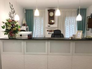Una cocina con una encimera con un jarrón de flores. en Hostal La Provinciana, en A Coruña