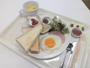 a plate of food with an egg and toast on a tray at HOTEL COLLECT in Sakai
