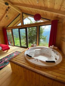 a large bath tub in a room with windows at Parla dağ evi kırmızı oda in Çamlıhemşin