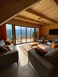 a living room with couches and a large window at Parla dağ evi kırmızı oda in Çamlıhemşin +31 photos