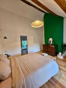 FrétoyにあるGrand Ferme entièrement rénovée - 1h de Paris 8paxの緑の壁のベッドルーム1室(大型ベッド1台付)