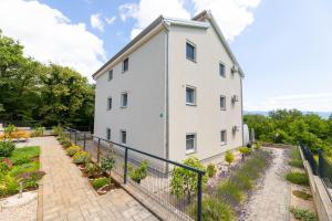 a white building with a fence next to a garden at Apartment Kristina by EL-PI Tours in Županje