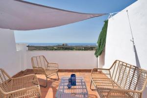 eine Terrasse mit drei Stühlen und einem Tisch und einem Zelt in der Unterkunft Duplex marinero con vista al mar gimnasio piscina - LAS ABEJERAS 615 in Estepona