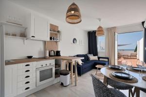 eine Küche und ein Wohnzimmer mit einem Tisch und einer Couch in der Unterkunft Duplex marinero con vista al mar gimnasio piscina - LAS ABEJERAS 615 in Estepona