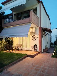 a house with a balcony and a patio at Artan`s garden house in Kalyves Poligirou