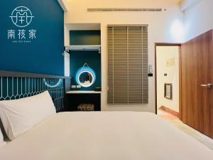 Un dormitorio con una cama blanca y una pared azul. en 南孩家-包棟民宿-6-8人-臺南市民宿第722號, en Tainan