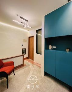 Una sala de estar con un armario azul y una silla roja. en 南孩家-包棟民宿-6-8人-臺南市民宿第722號, en Tainan 15 fotos más