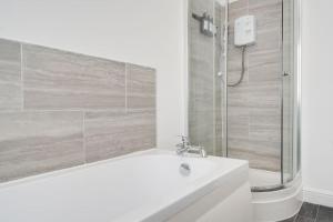 y baño con ducha y bañera blanca. en Park House - By Sigma Stays, en Crewe