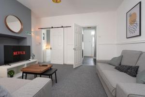 una sala de estar con un sofá y una mesa en Park House - By Sigma Stays, en Crewe
