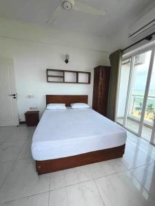 een slaapkamer met een groot bed en een groot raam bij Paradise in Mount Lavinia in Dehiwala