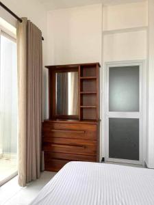 een slaapkamer met een bed, een ladekast en een raam bij Paradise in Mount Lavinia in Dehiwala +2 foto's