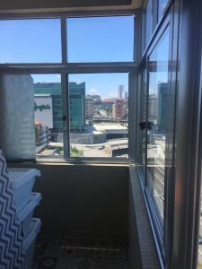 une fenêtre avec vue sur les toits de la ville dans l'établissement Quarto junto ao El Corte Inglés, à Vila Nova de Gaia