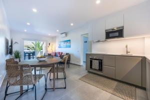 a kitchen and dining room with a table and chairs at O Golfinho in Lagos