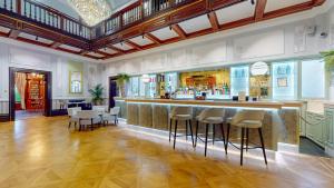 a restaurant with a bar with stools in a room at Oakley Hall Hotel in Basingstoke