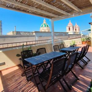 a patio with two tables and chairs on a balcony at Palazzo Dei Corsari in Trapani