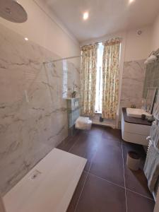 a bathroom with a tub and a sink and a mirror at Le Petit Château Peltzer in Verviers