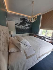 a bedroom with a large bed with white sheets and pillows at Le Petit Château Peltzer in Verviers