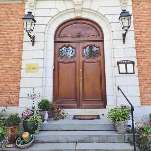 a wooden door on a brick building with stairs at Le Petit Château Peltzer in Verviers