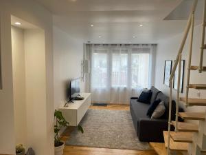 a living room with a couch and a television at Appartement dans une maison cosy in Chartres