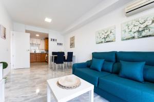 salon z niebieską kanapą i stołem w obiekcie Fuengirola Los Pacos Vistamar w mieście Fuengirola