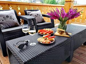 a table with a plate of fruit and glasses of wine at Chaty Misiagi - domki na wynajem in Poronin