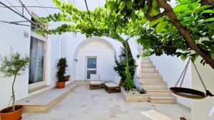 a courtyard with stairs and plants in a building at Corte Dioniso Eco Apartments & Suites in Crispiano +57 photos