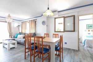 a dining room and living room with a table and chairs at Apartamentos El Puerto, La Savina in La Savina
