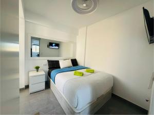 英格兰海滩JeLe Guest Room的一间白色的小卧室,配有床和镜子