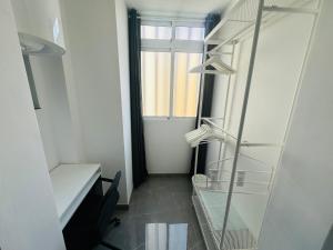 英格兰海滩JeLe Guest Room的小房间设有书架和窗户