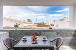 a table with a bowl of fruit on a balcony at Apartamentos El Puerto, La Savina in La Savina