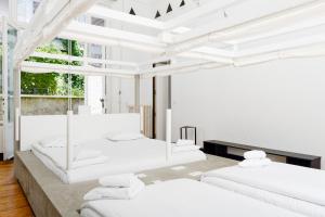 a white room with four beds in it at B&B DRUUM in Brussels