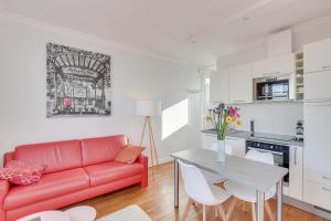 ein Wohnzimmer mit einem roten Sofa und einem Tisch in der Unterkunft Eiffel tower view and terrace in Paris