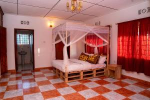 a bedroom with a canopy bed in a room at Karibu Nyumbani Hostel in Sokon
