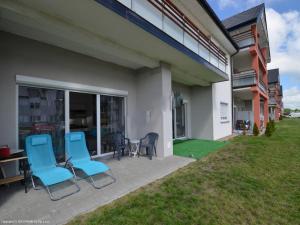 a patio with two blue chairs and a table at Apartament Bałtyk in Darłowo