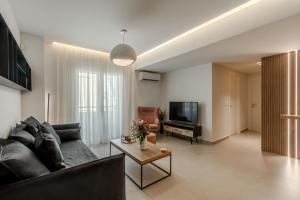 Una sala de estar con un sofá y un televisor. en Dreamy 2 BD Apt in the Heart of the city by Hospi, en Heraclión