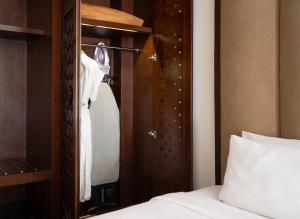 a bedroom with a bed and a wooden closet at MERUSAKA Nusa Dua in Nusa Dua