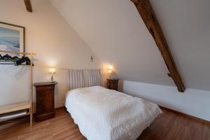 Un dormitorio con una cama blanca y dos lámparas. en Le Cosquer sur Zur, en Surzur