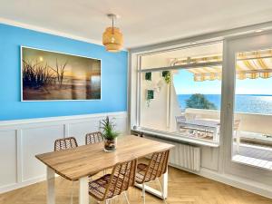 a dining room with a table and a view of the ocean at FeWo Traumblick - Himmel & Meer - TRAUM Panorama Meerblick, direkt am Strand mit großem Balkon in Sierksdorf