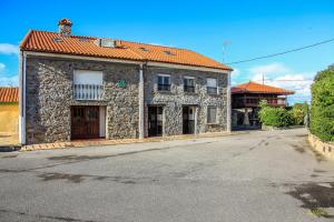 an old stone building with an empty street at La Morada del Cabo Peñas FOLU-GOZON-LUANCO in Luanco