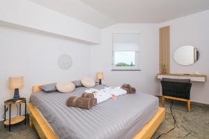 a bedroom with a large bed with blankets and pillows at PERLA VERDE Apartments in Krk +29 photos