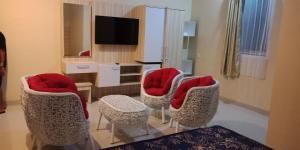a living room with four chairs and a television at D'Wantys Hotel in Ternate