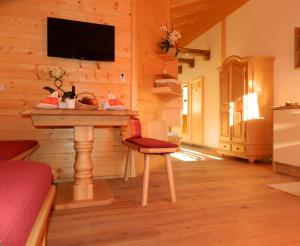 ein Wohnzimmer mit einem Tisch und einem TV an der Wand in der Unterkunft Haus Schwaiger in Bad Hofgastein