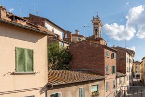 a group of buildings with a clock tower in the background at La Casina in Foiano della Chiana