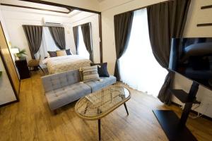 a living room with a couch and a bed at Junglia Okinawa 崎本部戸建プール付き f in Motobu