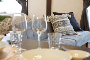 a table with wine glasses on it with a couch at Junglia Okinawa 崎本部戸建プール付き f in Motobu