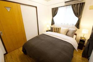 a bedroom with a large bed and a window at Junglia Okinawa 崎本部戸建プール付き f in Motobu