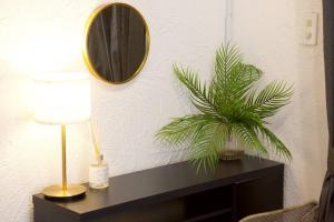 a table with a lamp and a mirror on a wall at Junglia Okinawa 崎本部戸建プール付き f in Motobu