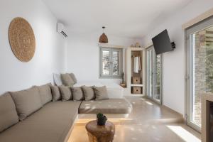 a white living room with a couch and a tv at Rabela's in Kollimpithra